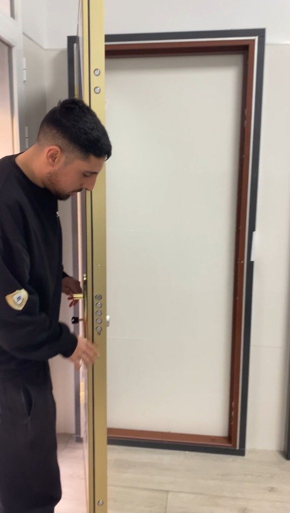 Revisión de una puerta de seguridad Técnico revisando la cerradura multipunto de una puerta de seguridad abierta